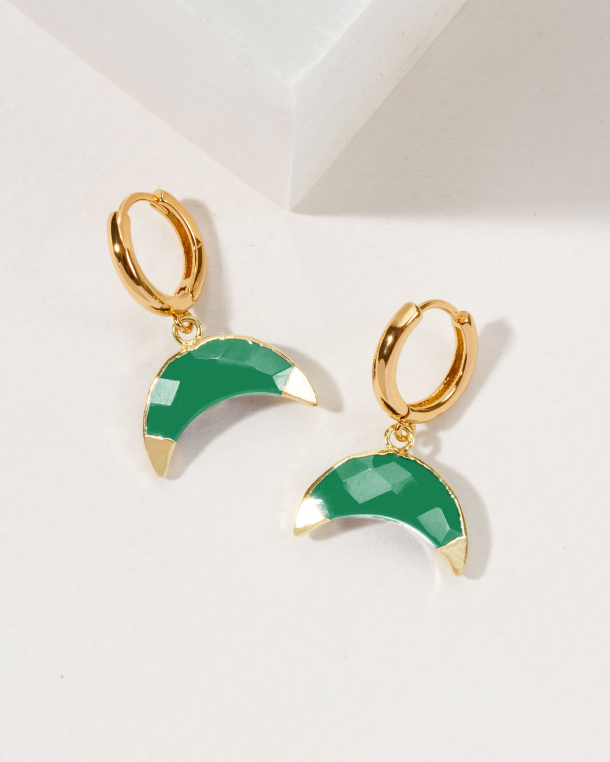 Crescent horn huggie hoop earrings with green chalcedony gemstones and gold-tone hoops.