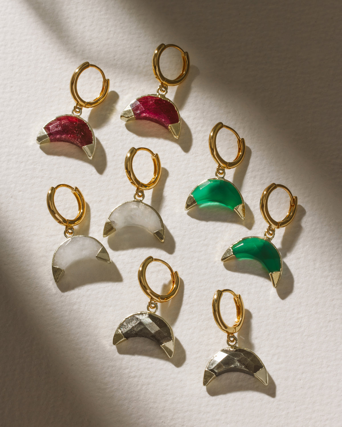 Crescent Horn Huggie Hoop Earrings in ruby, moonstone, pyrite, and green chalcedony.