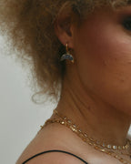 Crescent Horn Huggie Hoop Earring with a Labradorite gemstone, worn in an ear.