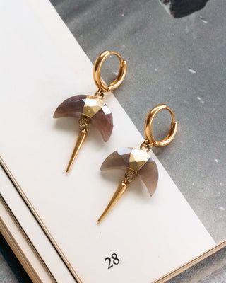 Huggie hoop earrings with a faceted Coffee Moonstone crescent horn charm and gold spike accent on a white and grey background.