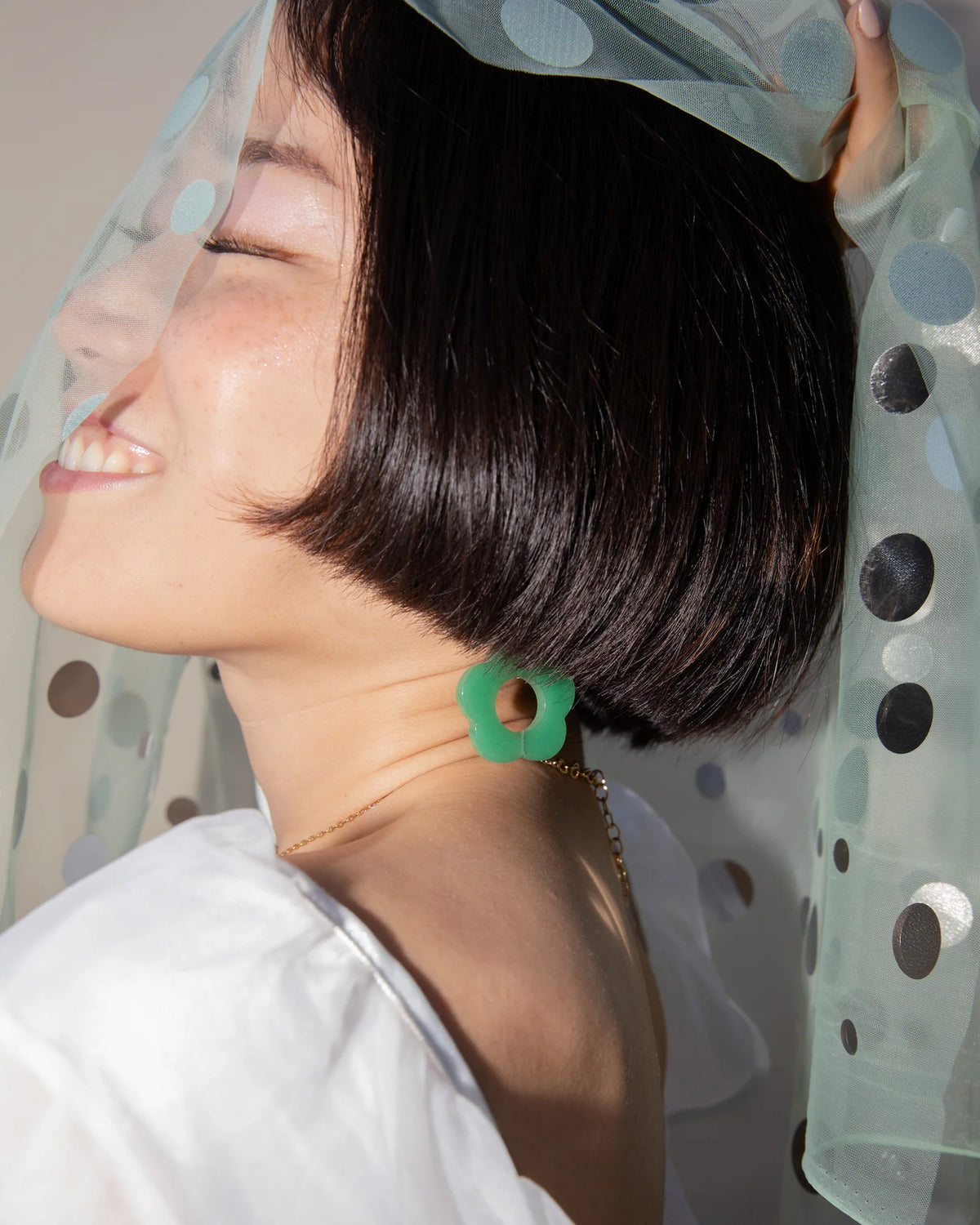 Profile view of a person wearing the Oops-A-Daisy Earrings in Green Aventurine.