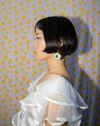 Side view of a person wearing a flower-shaped, green aventurine Oops-A-Daisy earring.
