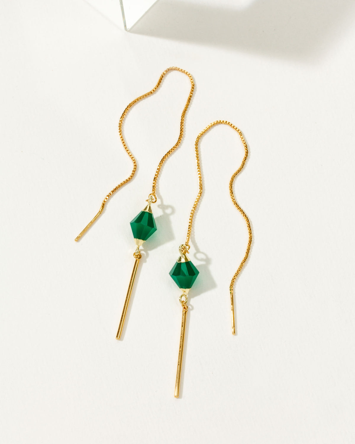 Pendulum threader earring with a faceted green chalcedony stone and gold-colored metal accents.