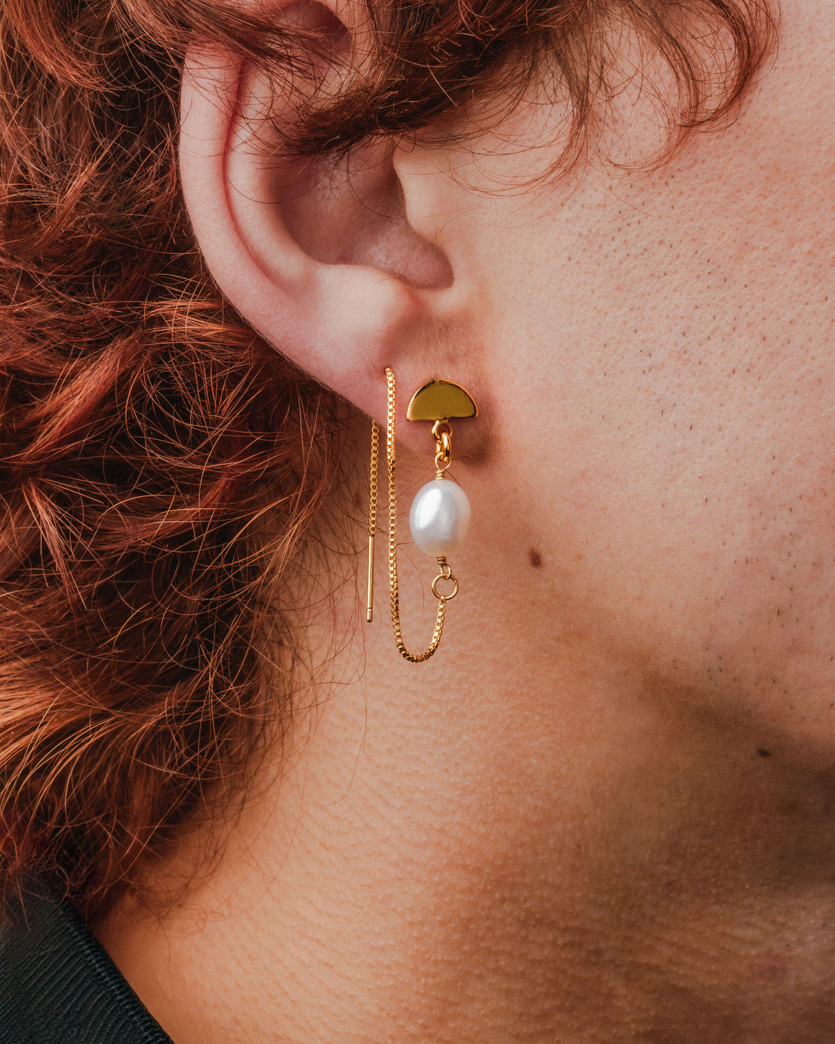 Close up of a gold Art Deco Pearl Threader Earring, featuring a freshwater pearl, on a model.