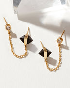 Midnight Serenade double-pierced earrings with gold chain, a crystal stud, and pyramid onyx stones.