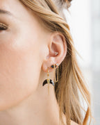 Close up of a woman's ear wearing Onyx Midnight Serenade Double Pierced Earrings.