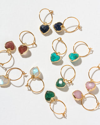 Gold hoop earrings with heart-shaped gemstone charms in multiple colors, including turquoise, emerald green, pink, purple, and dark blue.