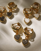 Gold huggie hoop earrings with heart charms in Black Druzy and White Druzy.