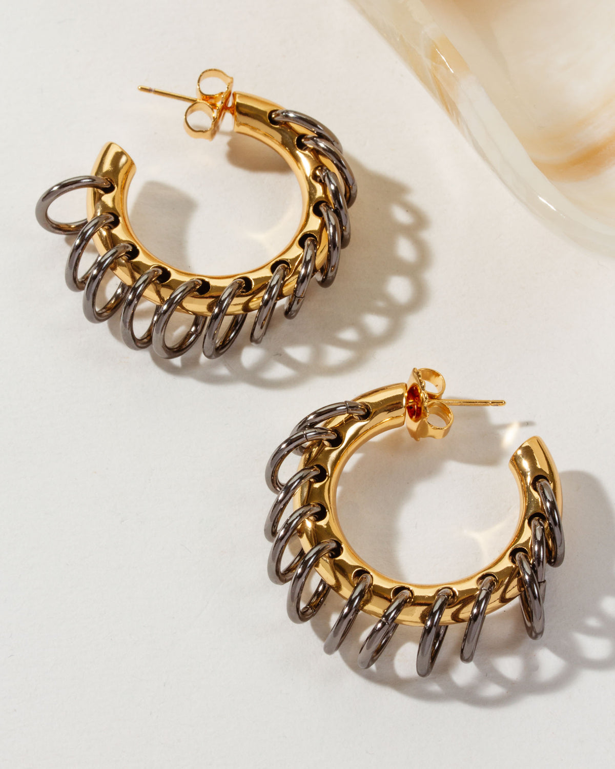 Two Golden Eclipse Vertebrae Post Hoop Earrings featuring gold hoops and oxidized metal links.