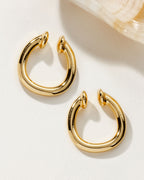 High-polish gold Illusive Conch Ear Cuff Adornment pair set against a light backdrop.