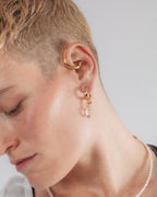 Model wearing earring cuff and charm hoops