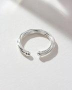 Silver Helix Twisted Conch Single Ear Cuff on a white surface, top view.