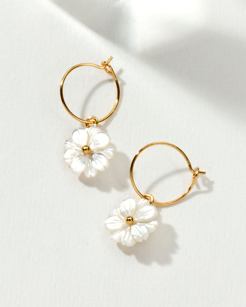 Pair of gold hoop earrings with mother of pearl shell daisies.