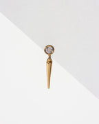 Gold Unspoken Solo Stud Earring with bezel-set CZ and tapered spike charm, on a white background.