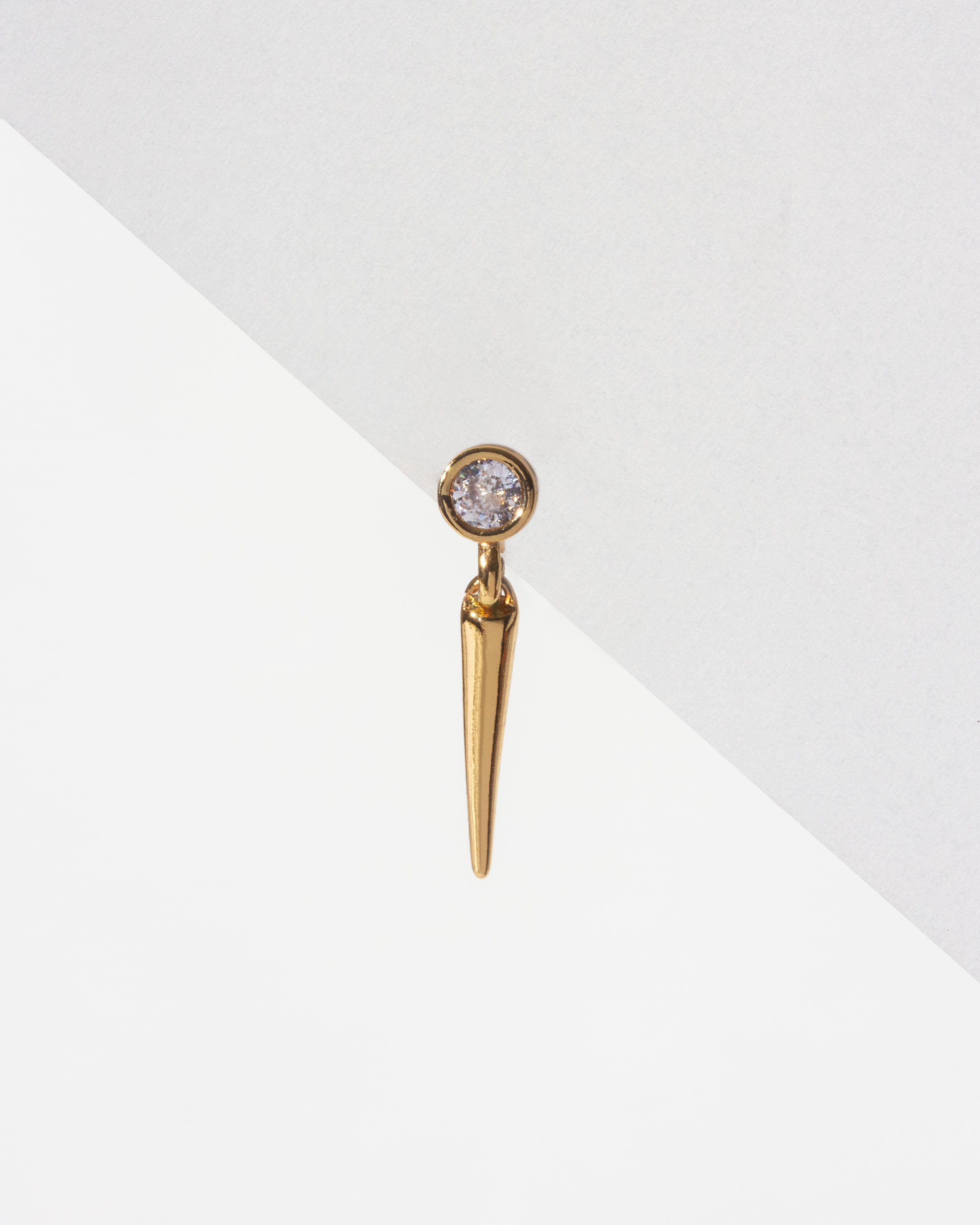 Gold Unspoken Solo Stud Earring with bezel-set CZ and tapered spike charm, on a white background.
