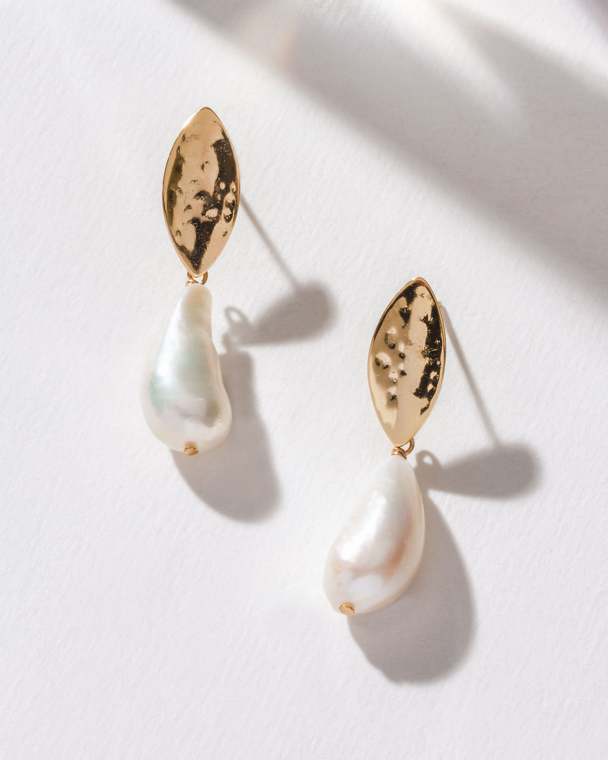 Two Pearl Tide Post Earrings with a gold textured post and white baroque freshwater pearl.