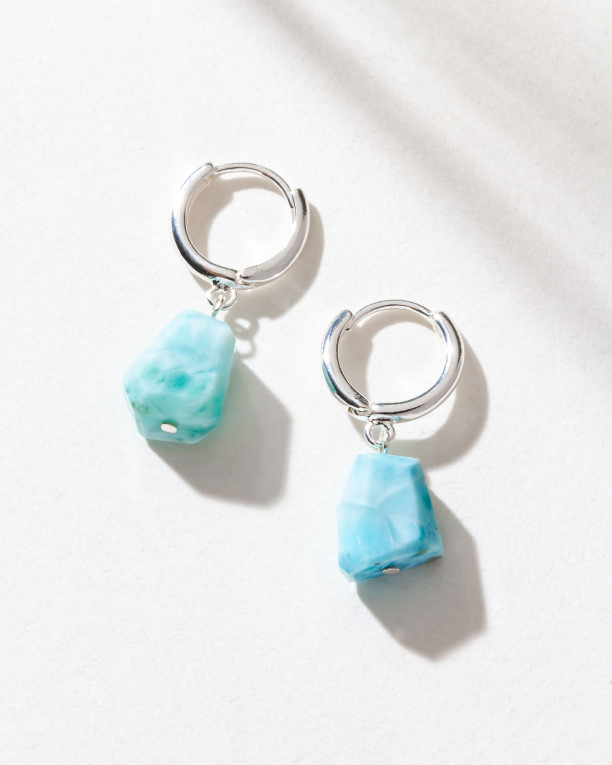 Two Sterling Silver Tropical Tide Huggie Hoop Earrings with larimar gemstones are
