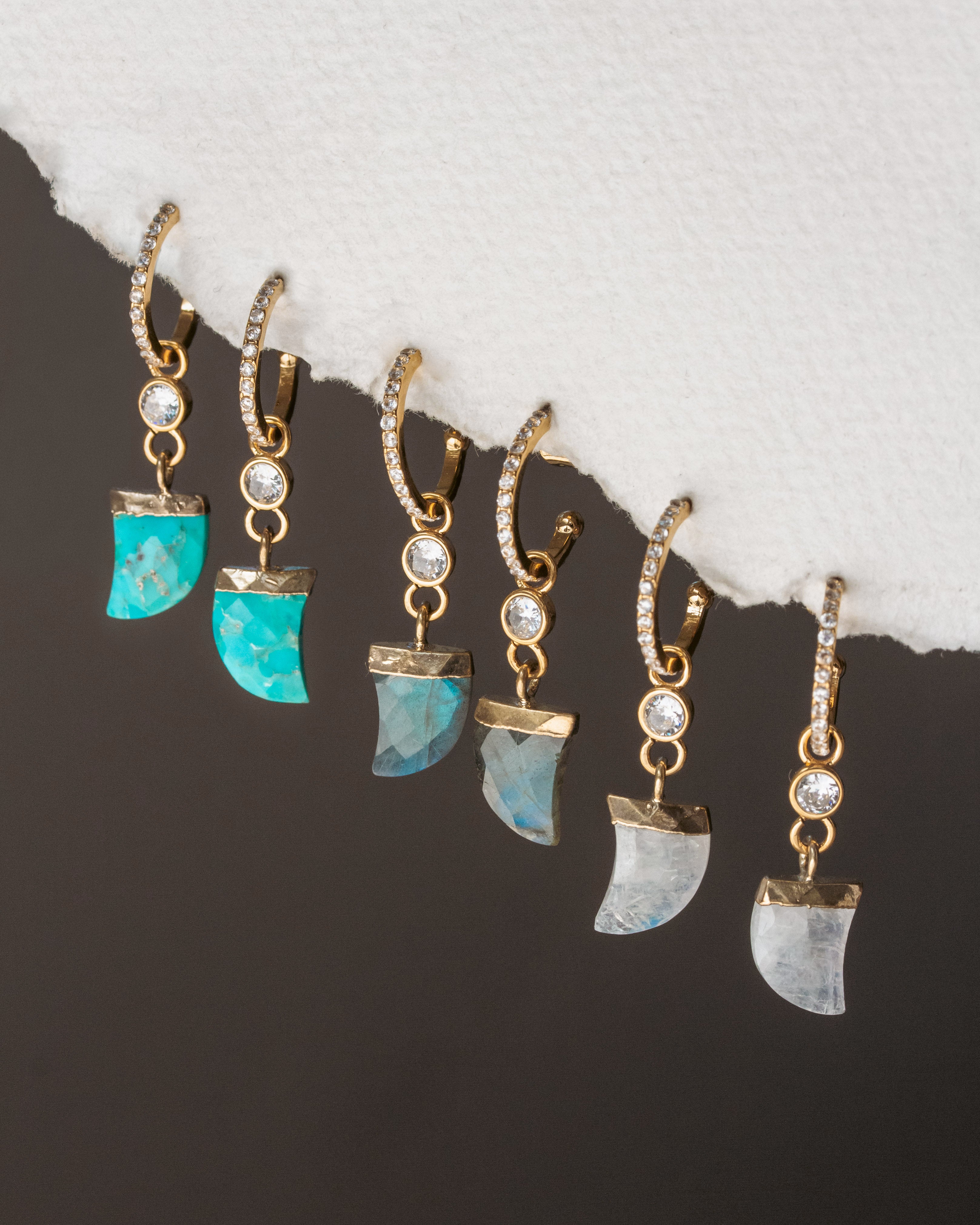 Set of earrings with turquoise and gemstone accents on a dark background