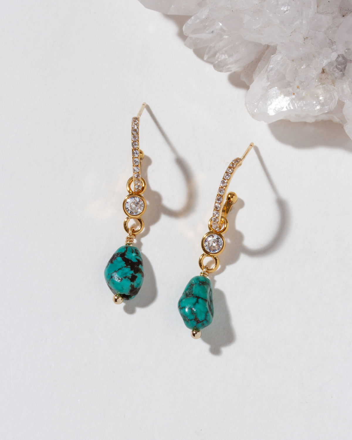 Gold and CZ earrings with turquoise stones on a white background