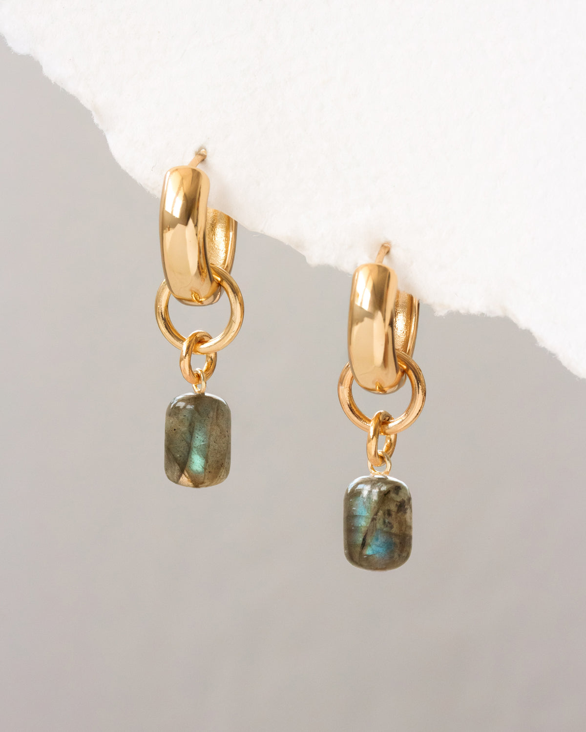 Gold hoop earrings with Labradorite stones on a light gray background