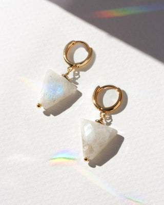Pair of earrings with gold hoops and moonstone gemstones on a white background