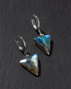Pair of triangular labradorite earrings on a dark gray background