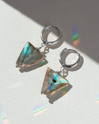 Triangular gemstone earrings on a light background