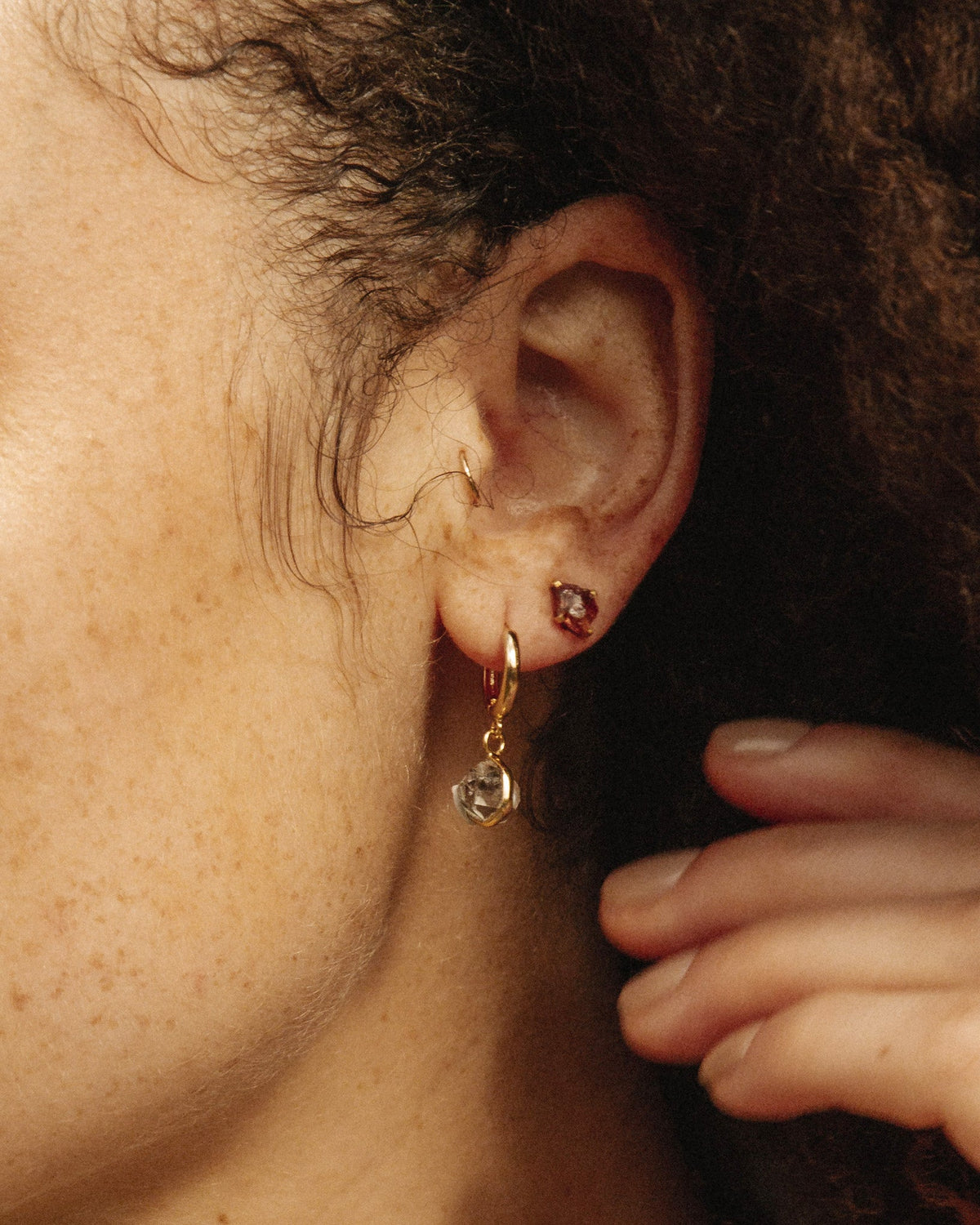 Ear with mismatched 14KT gold plated brass earrings: one stud, one Herkimer Quartz drop earring.