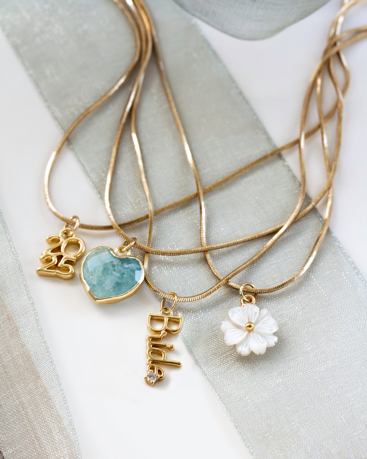 Gold necklaces with Bride, 2025, aquamarine heart, and mother-of-pearl heart charms