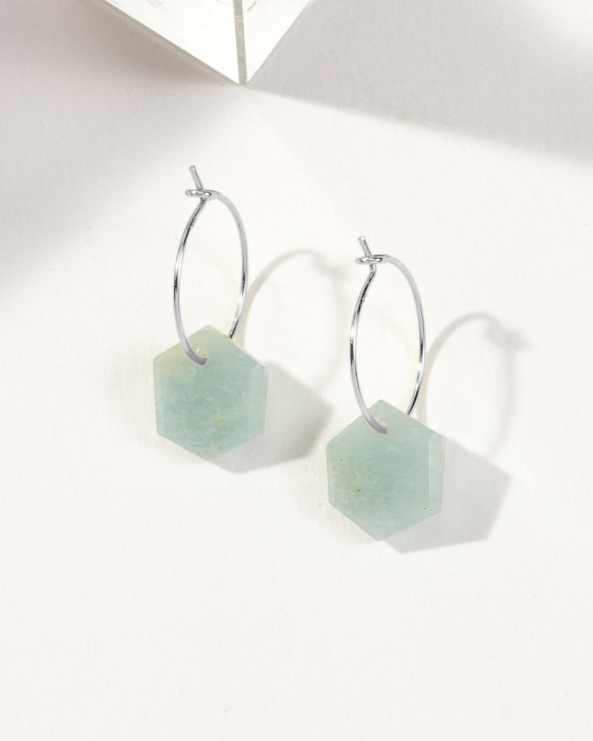 Aquamarine geometric shaped sterling silver hoop hearings on a white background.