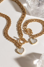 Gold chain necklace and bracelet with Mother of Pearl heart pendants and a toggle clasp.