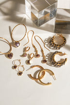 Golden hoop earrings with oxidized vertebrae links, embodying a yin and yang essence.