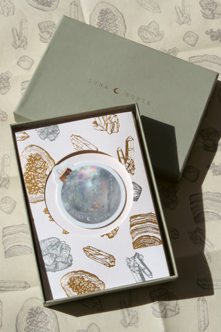 Gift card with crystal design with ornament sticker placed on top of gift box and wrapping paper set