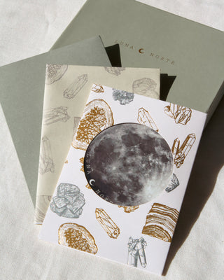 Gift card with crystal design with moon sticker placed on top of gift box and wrapping paper set