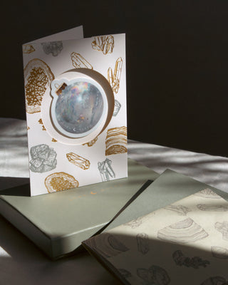 Gift card with crystal design with ornament sticker placed on top of gift box and wrapping paper set