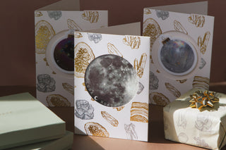 3 Gift cards with crystal design with moon and ornament stickers placed next to gift box with bow