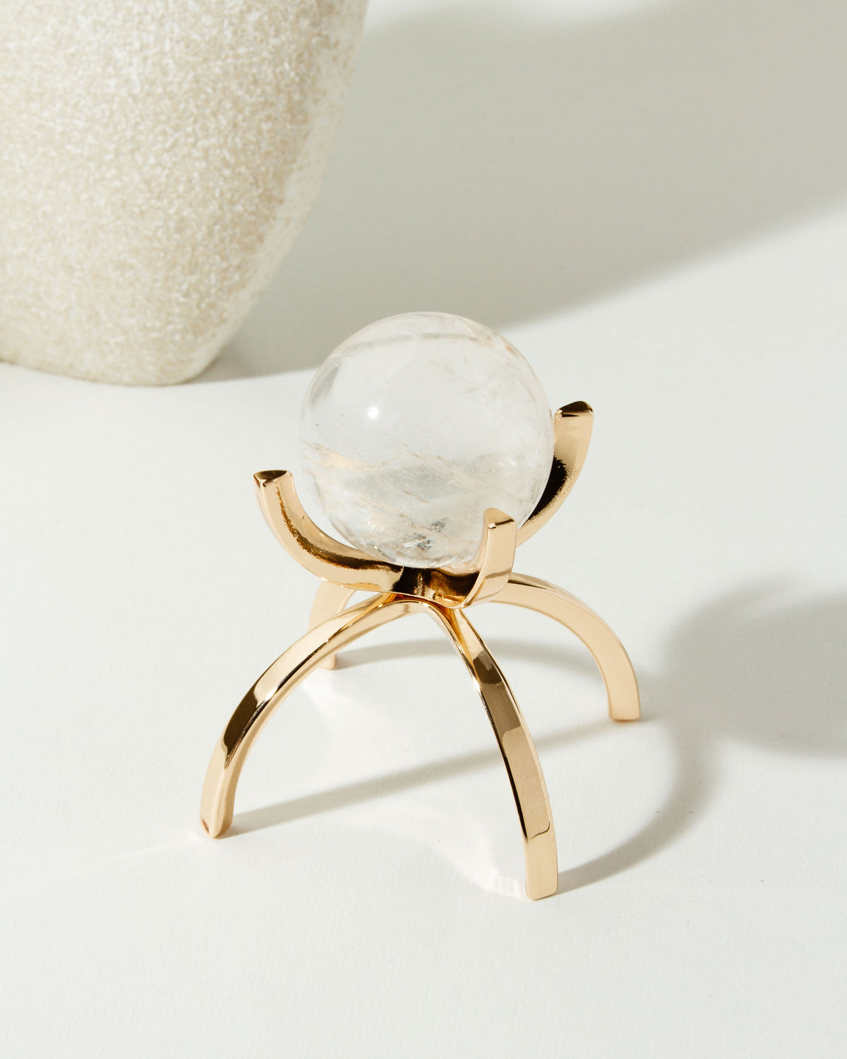 Clear Quartz sphere on a gold stand.