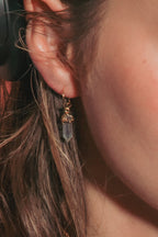 A close-up  shot of a woman wearing small crystal point dainty gold hoop.