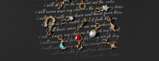 Various gemstone charms overlayed a chalkboard background with text "i will never wear my charms the same way twice"
