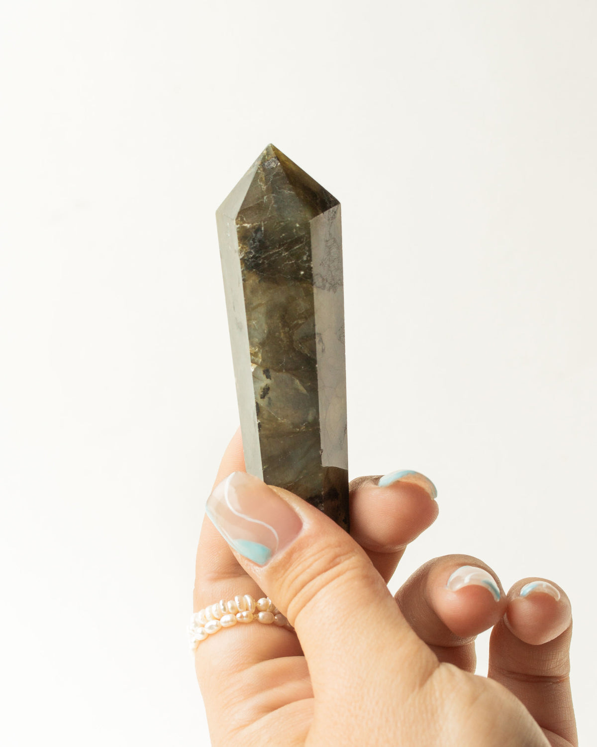 Labradorite double point crystal being held in a hand.