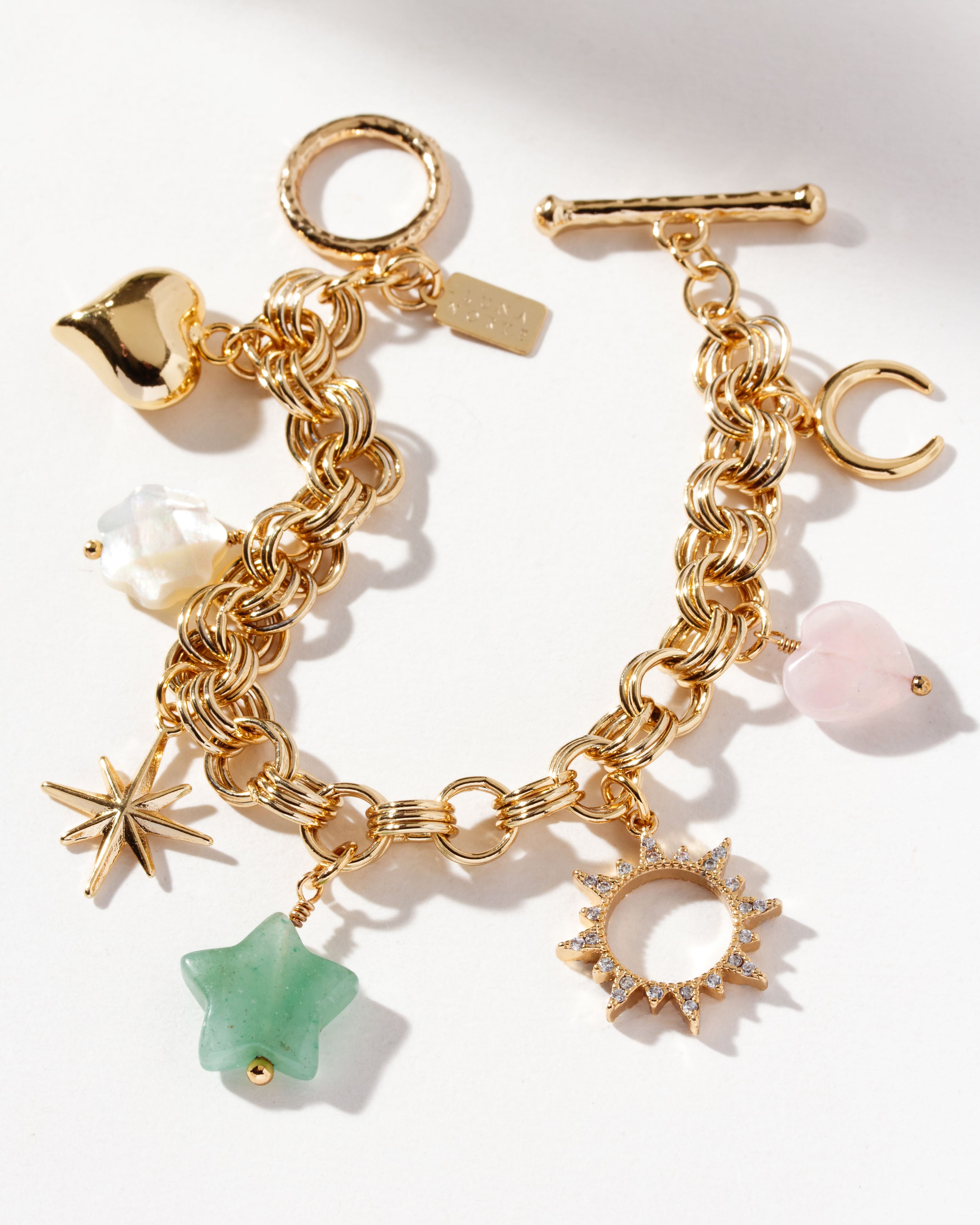 Gold-plated charm bracelet with charms with a heart, a flower, a star, and gem beads.