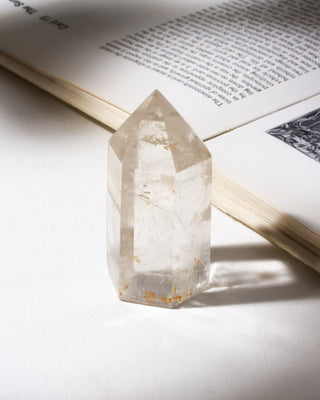 Quartz crystal tower near an open book with a soft focus background