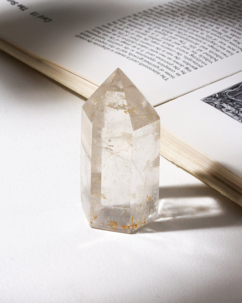 Quartz crystal tower near an open book with a soft focus background