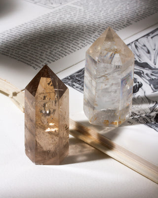 Two crystal points on an open book with a white surface