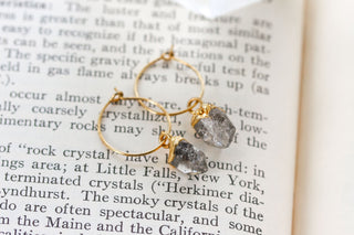 Gold hoop earrings with raw, rough-cut clear Herkimer quartz gemstones.