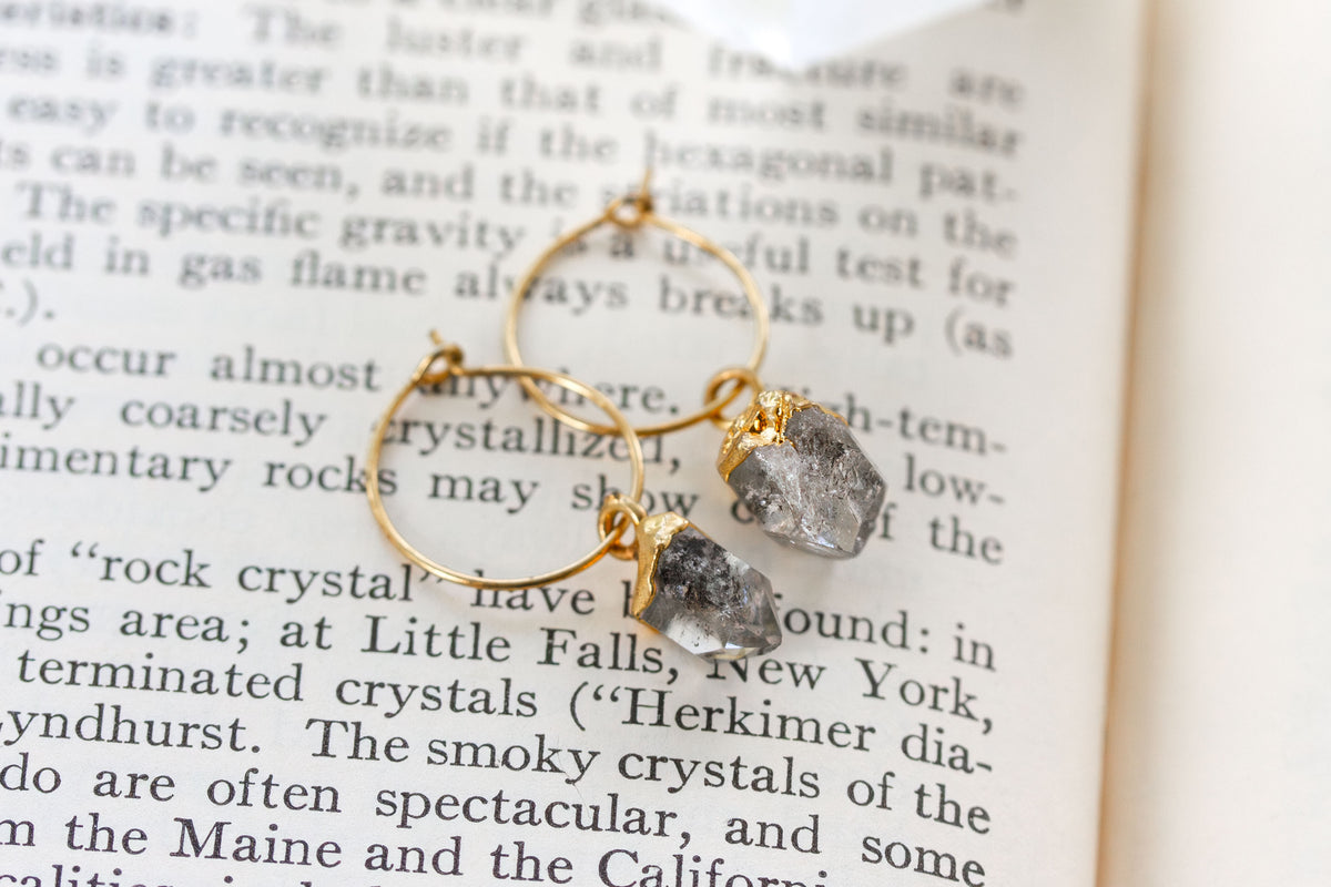 Gold hoop earrings with raw, rough-cut clear Herkimer quartz gemstones.