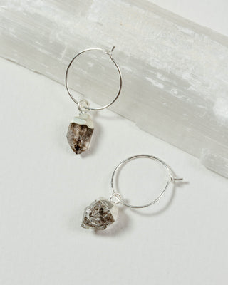 Sterling silver hoop earrings with raw, irregular clear Herkimer quartz gemstone dangles.