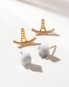 Two Twinkle Druzy Post earrings, with gold, cubic zirconia jackets, rest on a white surface.