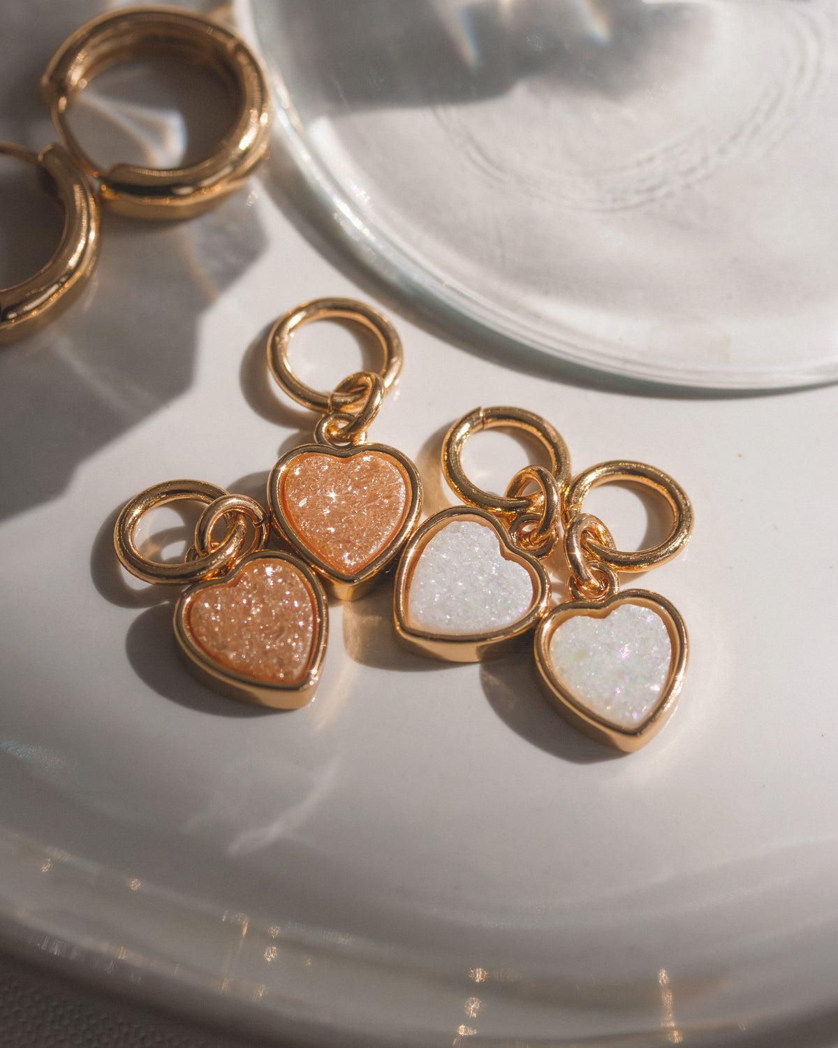 Two pairs of white and peach druzy quartz heart earring charms in gold settings