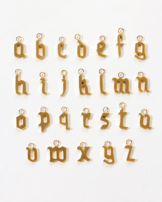 Alphabet of gold letter charms A through Z on a white background.
